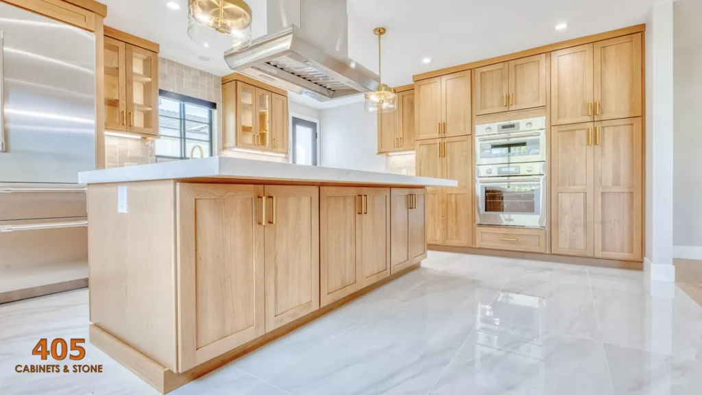 “Light-toned white oak kitchen cabinets with island and stainless appliances.