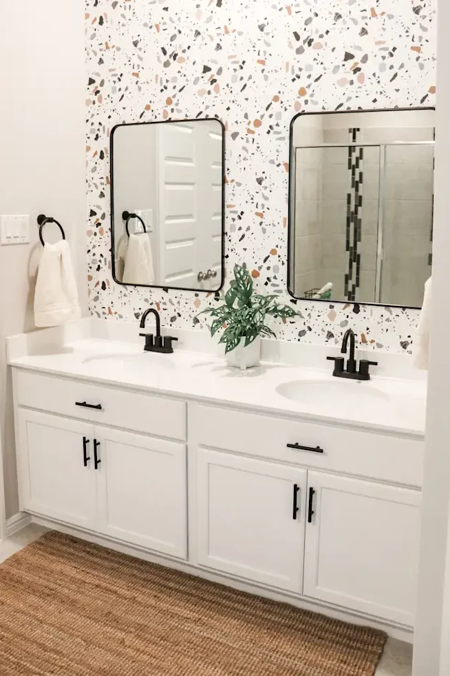 Speckled terrazzo-pattern wallpaper in a modern bathroom with simple fixtures