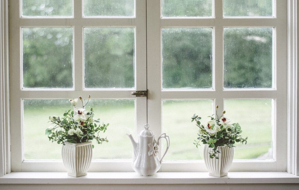 Pyntekvister: a large glass vase of bare birch branches placed near a window